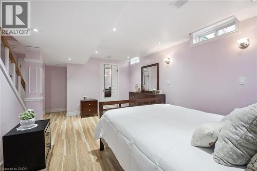 Recessed lighting illuminates this room featuring wood-finish flooring, white trim, and light purple walls - 5449 Rochelle Way, Mississauga, ON - Indoor Photo Showing Bedroom