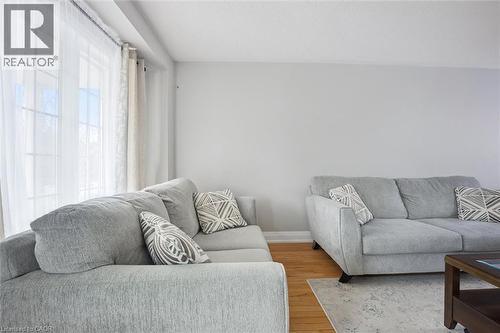 Spacious room featuring multiple large windows with sheer and opaque curtains, neutral wall paint, and wood-finish flooring - 5449 Rochelle Way, Mississauga, ON - Indoor Photo Showing Living Room