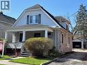 Traditional home featuring a covered front porch with classic columns, a stone façade, and dormer window with contrasting shutters - 838 Moore Street, Cambridge, ON  - Outdoor 