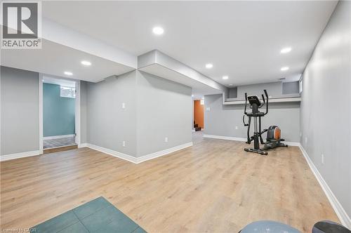 Finished basement featuring wood-finish flooring, recessed lighting, and neutral wall tones - 838 Moore Street, Cambridge, ON - Indoor
