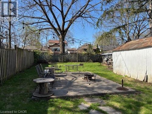 Expansive backyard featuring a concrete patio, a privacy fence, and a storage shed - 838 Moore Street, Cambridge, ON - Outdoor With Backyard