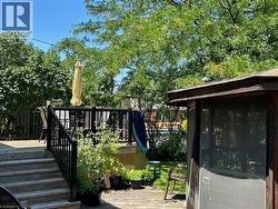 Multi-level wood deck featuring black metal railings and stairs - 