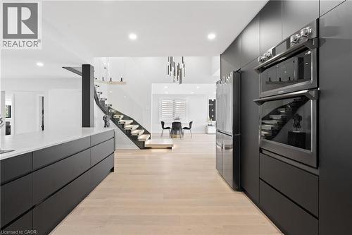 Kitchen with modern cabinets, dark cabinets, stainless steel appliances, light wood-style floors, and recessed lighting - 17 Clearview Drive, Hamilton, ON - Indoor Photo Showing Kitchen