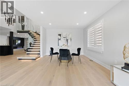 Open concept interior featuring light wood-finish flooring, recessed lighting, and a modern floating staircase with glass railings - 17 Clearview Drive, Hamilton, ON - Indoor
