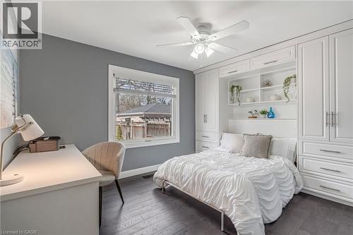 Integrated built-in cabinetry surrounding a bed frame, featuring multiple storage drawers and open shelving - 2123 Deyncourt Drive, Burlington, ON - Indoor Photo Showing Bedroom