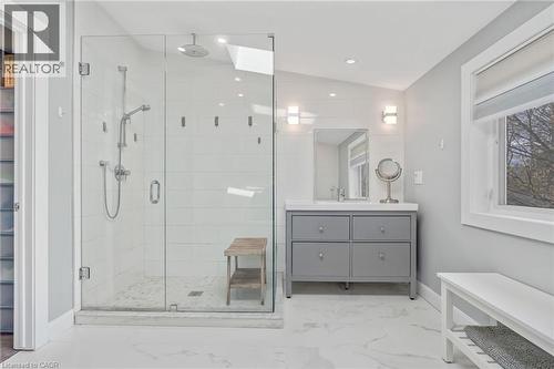 Spacious bathroom featuring a glass-enclosed shower with multiple showerheads, a skylight, and white subway tile - 2123 Deyncourt Drive, Burlington, ON - Indoor Photo Showing Bathroom