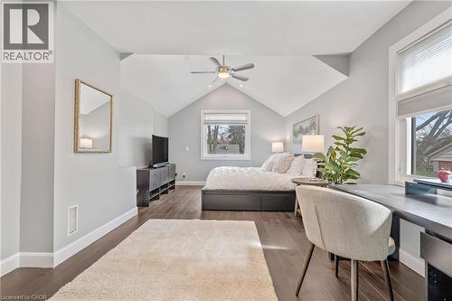Spacious room featuring vaulted ceilings, wood-finish flooring, a contemporary ceiling fan, and two windows providing natural light - 2123 Deyncourt Drive, Burlington, ON - Indoor Photo Showing Bedroom