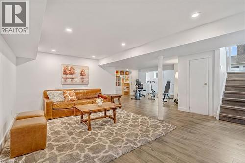 Lower-level finished space featuring wood-finish flooring, recessed lighting, and white walls - 2123 Deyncourt Drive, Burlington, ON - Indoor