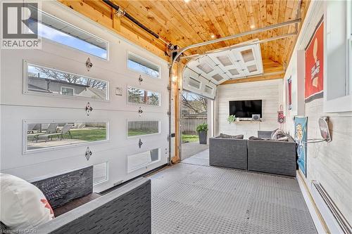 Versatile indoor-outdoor area featuring a wood-plank ceiling, white shiplap wall, and a garage door with multiple transom windows - 2123 Deyncourt Drive, Burlington, ON - Indoor Photo Showing Other Room