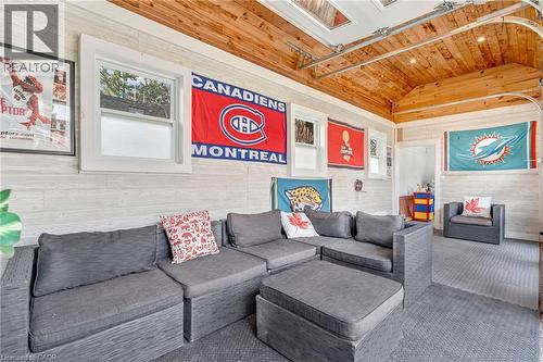 Recreational room featuring wood-paneled walls, a vaulted wood ceiling, and multiple windows - 2123 Deyncourt Drive, Burlington, ON - Indoor Photo Showing Living Room