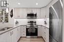 Kitchen featuring stainless steel appliances, tasteful backsplash, light stone counters, decorative light fixtures, and light wood finished floors - 3998 Victoria Avenue Unit# 105, Lincoln, ON  - Indoor Photo Showing Kitchen With Upgraded Kitchen 