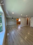 Unfurnished living room featuring dark wood-type flooring and recessed lighting - 