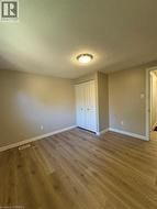 Unfurnished bedroom with dark wood finished floors, a textured ceiling, and a closet - 