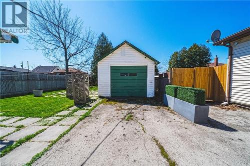 Detached garage with green door, concrete driveway, and concrete patio pavers - 28 Munn Street, Hamilton, ON - Outdoor