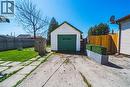 Detached garage with green door, concrete driveway, and concrete patio pavers - 28 Munn Street, Hamilton, ON  - Outdoor 