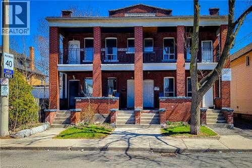 Brick facade featuring a columned porch with second-story balconies - 254 Emerald Street N Unit# Upper, Hamilton, ON - Outdoor With Facade