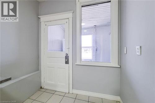 White paneled door with upper glass panel, white trim, and a rectangular window - 254 Emerald Street N Unit# Upper, Hamilton, ON - Indoor Photo Showing Other Room