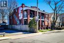 Brick exterior featuring a multi-story mural, two elevated balconies with black railings, and a fenced side yard - 254 Emerald Street N Unit# Upper, Hamilton, ON  - Outdoor With Facade 