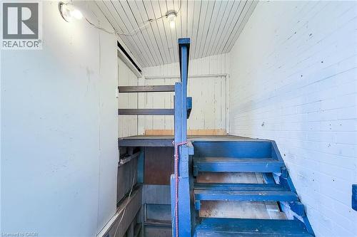 Painted wooden staircase with blue treads and risers, featuring a partial banister - 254 Emerald Street N Unit# Upper, Hamilton, ON - Indoor Photo Showing Other Room