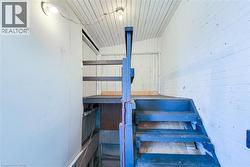 Painted wooden staircase with blue treads and risers, featuring a partial banister - 