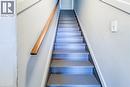 Staircase featuring painted treads and risers, a natural wood handrail, and light gray wall paint - 254 Emerald Street N Unit# Upper, Hamilton, ON  - Indoor Photo Showing Other Room 