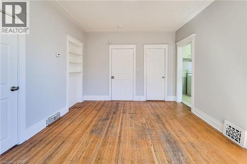 Warm wood flooring throughout, complemented by light gray walls and white trim - 254 Emerald Street N Unit# Upper, Hamilton, ON - Indoor Photo Showing Other Room