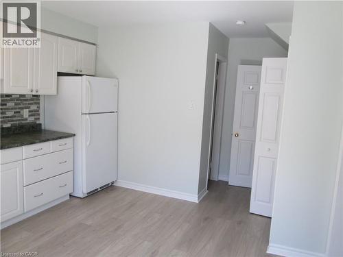 Kitchenette featuring white cabinetry, dark speckled countertops, and a mosaic tile backsplash - 648 Francis Road, Burlington, ON - Indoor