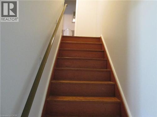 Hardwood staircase featuring a brass handrail and white risers - 648 Francis Road, Burlington, ON - Indoor Photo Showing Other Room