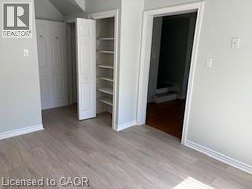 Light wood-finish flooring featuring a built-in shelving unit and bi-fold closet doors - 648 Francis Road, Burlington, ON - Indoor Photo Showing Other Room