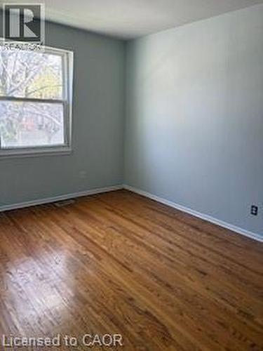 Bright interior room featuring wood-finish flooring, light-toned walls, and a window with white trim - 648 Francis Road, Burlington, ON - Indoor Photo Showing Other Room