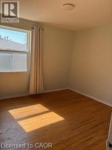 Room featuring wood-finish flooring, a double-hung window, baseboards, and a flush-mount ceiling light - 648 Francis Road, Burlington, ON - Indoor Photo Showing Other Room