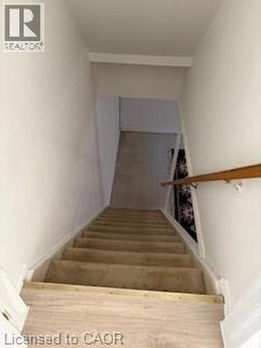 Carpeted staircase with a wood handrail and light-toned wall finishes - 648 Francis Road, Burlington, ON - Indoor Photo Showing Other Room