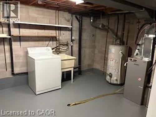 Utility area featuring a laundry sink, exposed structural elements, and concrete block walls - 648 Francis Road, Burlington, ON - Indoor