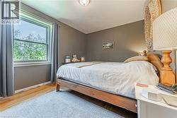 Hardwood-style flooring extends throughout this room, complemented by a large window - 