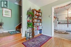 Hardwood flooring extends from the entryway, featuring a staircase with matching wood treads - 