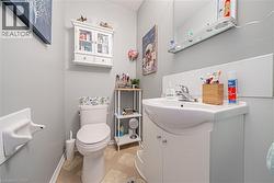 Bathroom featuring a white vanity with integrated sink, chrome faucet, white wall paneling, and light-toned geometric pattern flooring - 