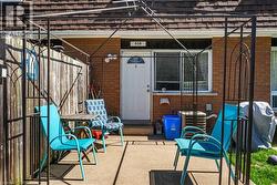 Private patio area featuring a concrete surface, a decorative metal pergola frame, and a wooden privacy fence - 