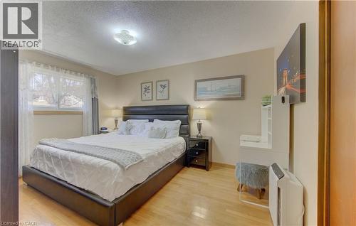 Bedroom featuring wood-finish flooring, a double window with light-filtering privacy sheers, and crown molding - 170 Martinglen Crescent, Kitchener, ON - Indoor Photo Showing Bedroom