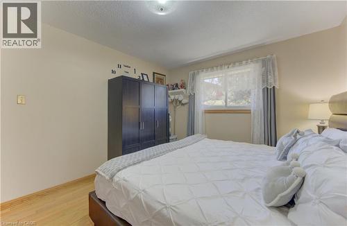 Light-toned walls with wood-finish flooring - 170 Martinglen Crescent, Kitchener, ON - Indoor Photo Showing Bedroom