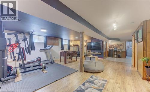 Expansive finished basement featuring wood-finish flooring, recessed lighting, and exposed wooden structural columns - 170 Martinglen Crescent, Kitchener, ON - Indoor Photo Showing Gym Room