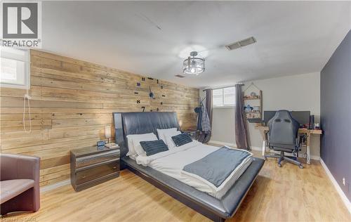 Accent wall with horizontal wood paneling and light wood-finish flooring - 170 Martinglen Crescent, Kitchener, ON - Indoor Photo Showing Bedroom