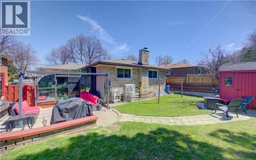 Expansive backyard featuring a stone patio, manicured lawn, and paved walkway - 170 Martinglen Crescent, Kitchener, ON - Outdoor With Deck Patio Veranda