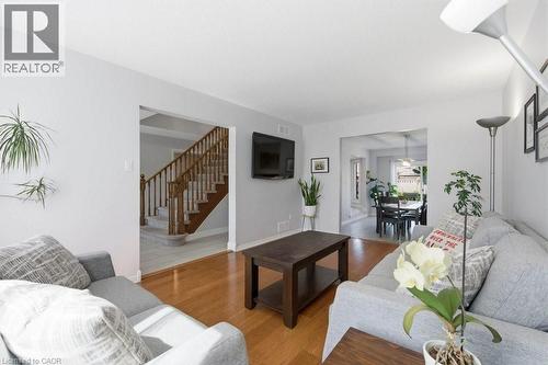 Living area featuring wood-finish flooring, light grey walls, and an open doorway to a dining space - 44 Lorilee Crescent, Kitchener, ON - Indoor Photo Showing Living Room