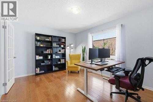 Hardwood-finish flooring highlights this versatile room featuring a bright window, a flush mount ceiling light, and a French door entry - 44 Lorilee Crescent, Kitchener, ON - Indoor Photo Showing Office