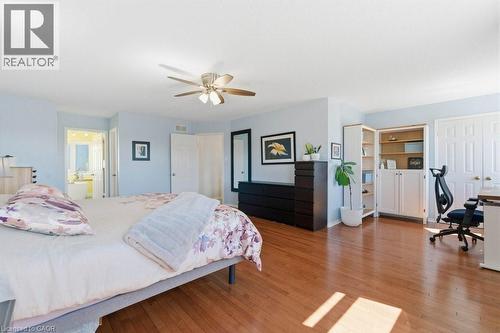 Spacious room featuring wood-finish flooring, a ceiling fan, light blue wall paint, and built-in shelving with cabinet storage - 44 Lorilee Crescent, Kitchener, ON - Indoor Photo Showing Bedroom