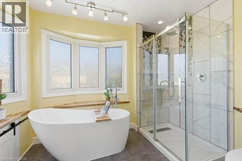 Freestanding soaking tub positioned under a bay window with wood-finish sill - 44 Lorilee Crescent, Kitchener, ON - Indoor Photo Showing Bathroom
