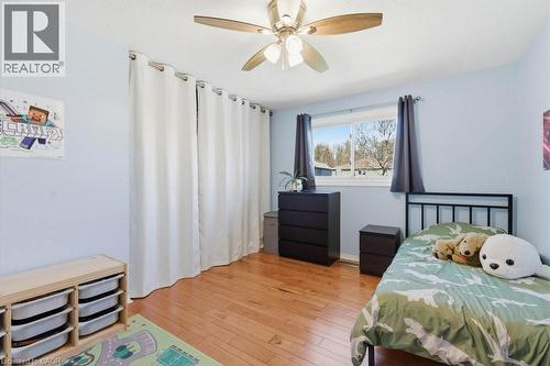 Light blue walls complement the wood-finish flooring in this room featuring a window with exterior views - 44 Lorilee Crescent, Kitchener, ON - Indoor Photo Showing Bedroom