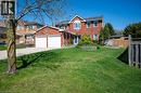 Two-story brick residence featuring a two-car garage with individual doors, a prominent bay window, and a blue front entry door - 44 Lorilee Crescent, Kitchener, ON  - Outdoor 