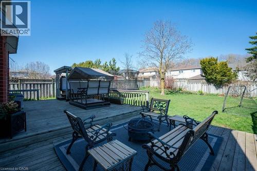 Expansive wood-finish deck with multiple seating areas, a fire pit, and direct access to a grassy yard - 44 Lorilee Crescent, Kitchener, ON - Outdoor With Deck Patio Veranda