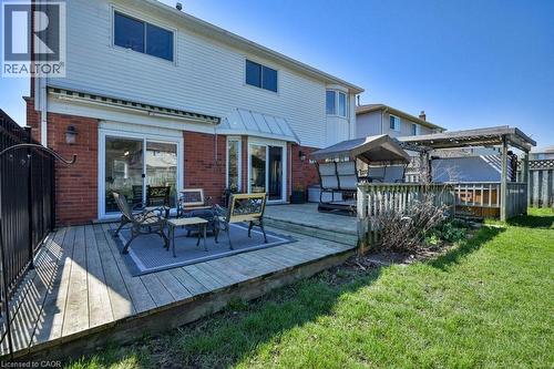 Spacious wood deck with pergola and sliding glass door access, bordered by a wrought iron fence and manicured lawn - 44 Lorilee Crescent, Kitchener, ON - Outdoor With Deck Patio Veranda